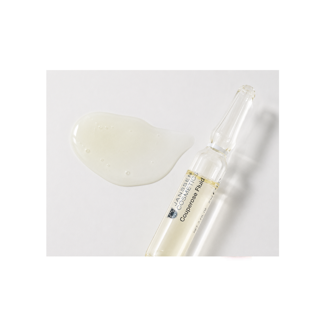 Cosmetic dropper with a small amount of white liquid on a light gray background