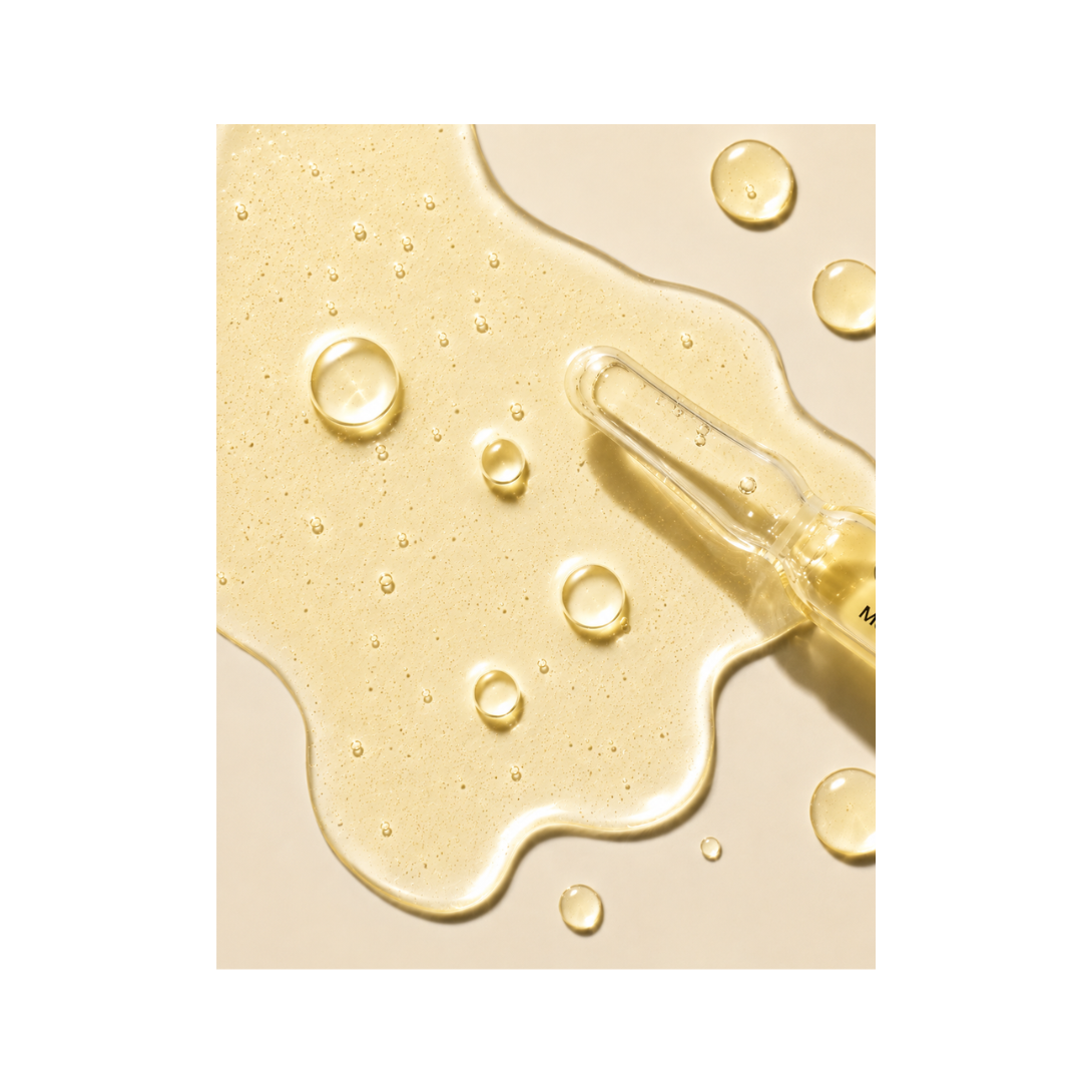Close-up of a ampoule with yellow liquid on a beige background